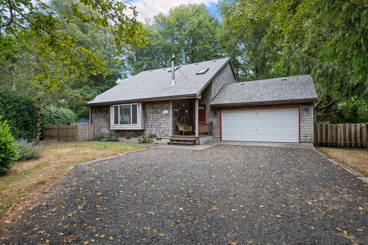 This image features the property's inviting front porch, driveway, and a well-maintained garden area. The porch is perfect for relaxing and the surrounding green space hints at outdoor activities and a pet-friendly environment.