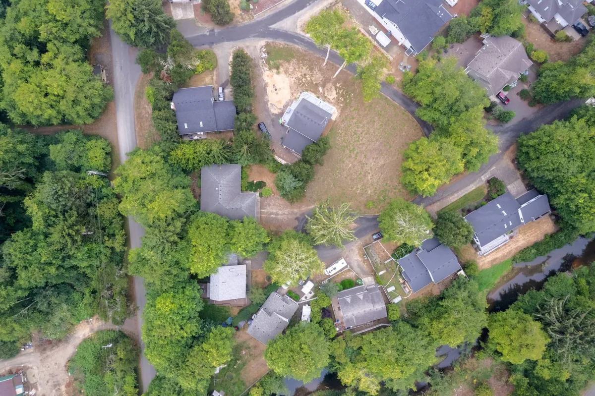 A peaceful neighborhood scene, with residential homes framed by lush greenery and winding roads, suggesting the surrounding area's natural beauty and opportunities for exploration.